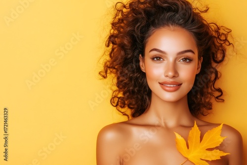 Woman holding autumn maple leaf smiling
