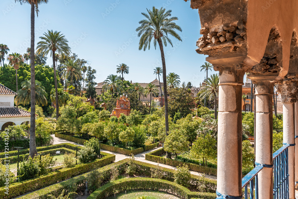 Naklejka premium A high-up view overlooking the gardens at the Real Alcazar de Sevilla or the Royal Alcazar of Seville in Spain. 
