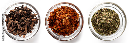 High-resolution image of three types of dried spices in transparent glass bowls on a white background, top view.