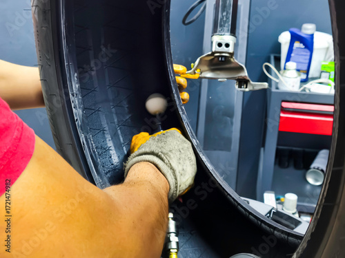The hole created by the nail removed from the tire is being repaired. Tire repair 
patch