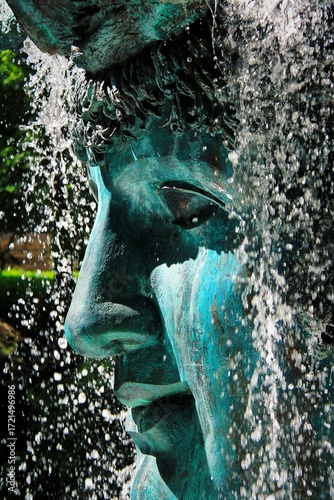 fountain in the park with a statue 