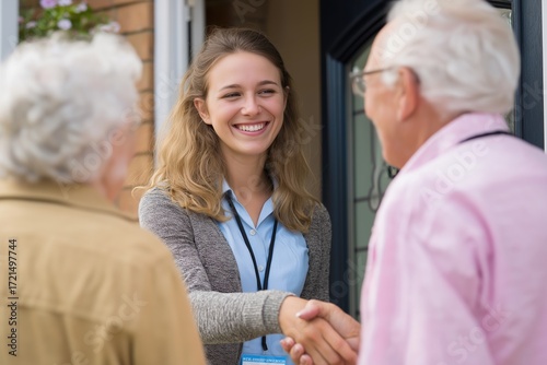 Friendly young caregiver shaking hands with a senior man at the door