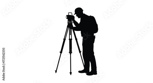 Silhouette of a surveyor using a theodolite on a tripod stand