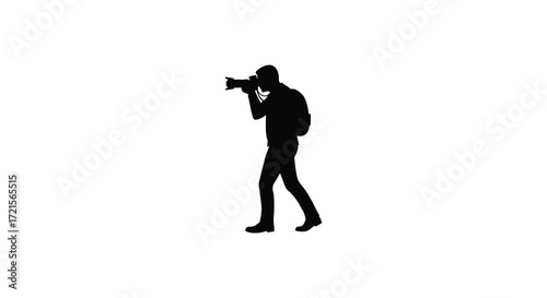 Silhouette of a photographer walking while operating a camera