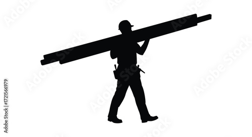 Silhouette of a construction worker carrying a long wooden beam