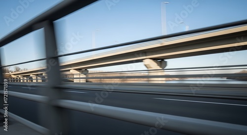 Dynamic Motion Blur View from a Car Window on a Modern Elevated Highway Bridge Over a River Against a Clear Blue Sky at High Speed
