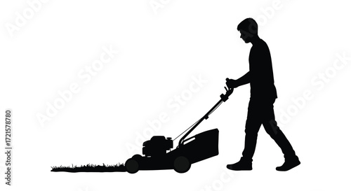 Silhouette of a man mowing a lawn with a push lawnmower