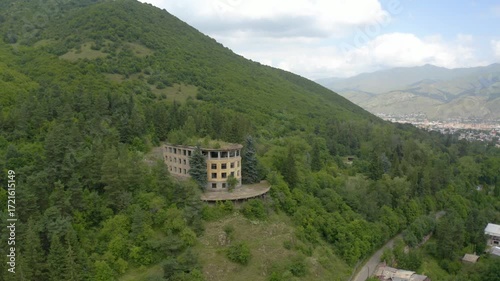 Aerial view abandoned building in forest.  Ruins near green trees. Aerial view  unoccupied, empty, deserted, Industrial building in nature.