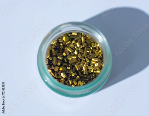 Shiny Golden Metal Granules in Glass Jar
