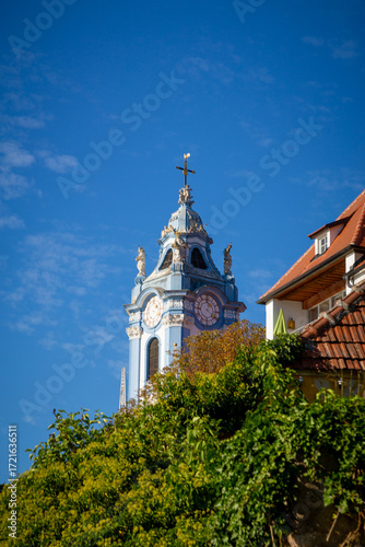 The iconic Baroque Blue Tower of Dürnstein Abbey dominates the picturesque town and surrounding Wachau Valley landscape in Austria, a renowned UNESCO World Heritage site.
