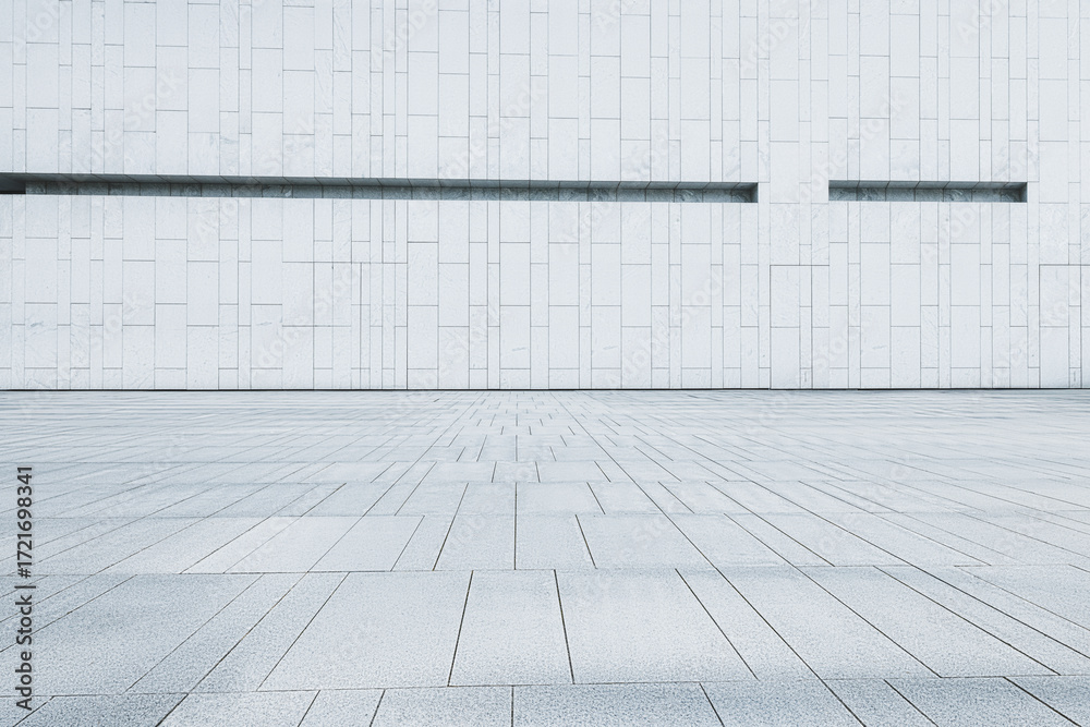 Fototapeta premium Empty clean stone tile floor with a minimalist modern white building wall background.