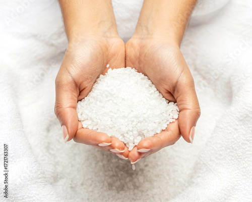 Woman's hands gently holding natural bath salts for a relaxing spa treatment and wellness ritual
