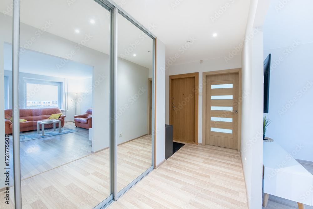 Obraz premium Modern Hallway With Wooden Floors and Reflections in Glass Panels