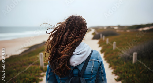 Woman walking away ocean wind blowing hair path beach travel journey adventure wanderlust freedom relaxation peace solitude escape nature calm