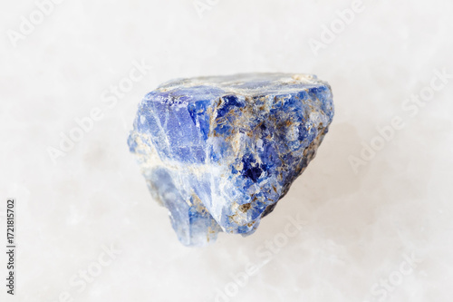sample of raw benitoite stone on white marble