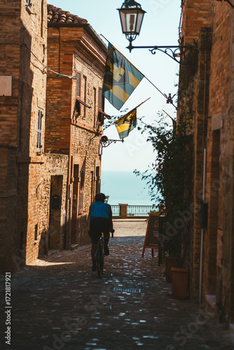 Palm Tower center with town banners and cyclist, the medieval city near Fermo in the Marche region