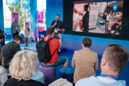Foto Vibrant conference scene shows presenter on stage, large screen displays, attent