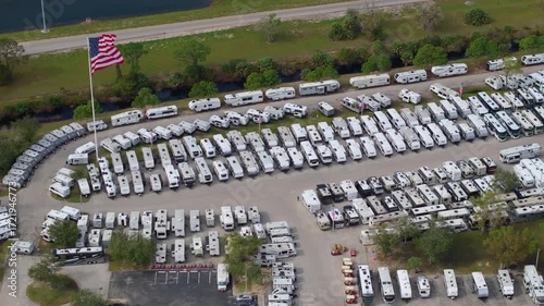 RV dealership parking lot with many brand new motorhomes for sale. Development of American recreational vehicles industry.