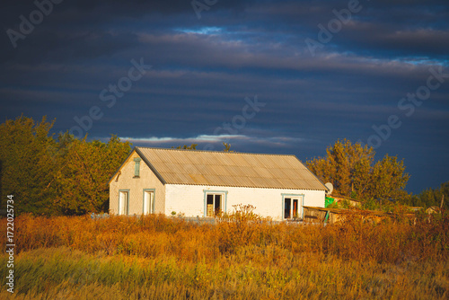 White house in norway. Lonely house in field in Scandinavian style at sunset..