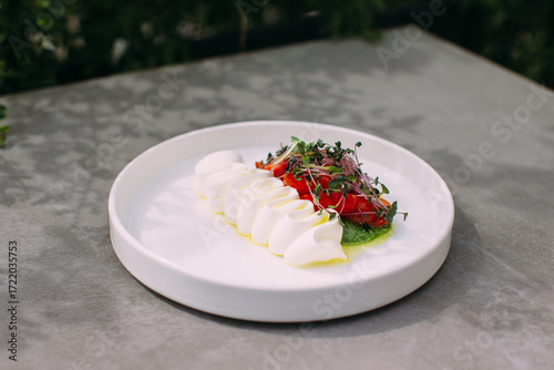 Fototapeta Naklejka Na Ścianę i Meble -  Caprese salad with mozzarella, tomatoes and microgreens