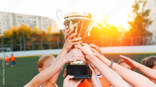 Konstfotografi Womens childrens football team celebrating victory with trophy