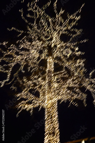 Foto Árbol nocturno cubierto de luces cálidas, brillando en la oscuridad con efecto suave y festivo