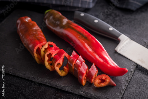 Corno di Toro Rosso pepper. Red paprika vegetable on black table.