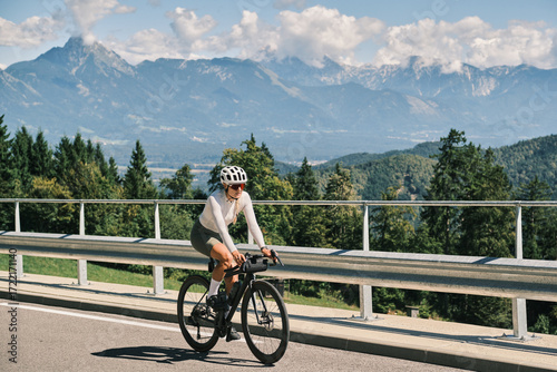 A woman cyclist enjoys a scenic mountain bike ride. Stunning panoramic views and a sense of freedom. Perfect for travel, adventure, and active lifestyle themes.