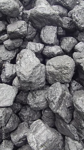 A pile of dark, lumpy coal gleams with a slight sheen, showing a rough, varied texture. Video 4k