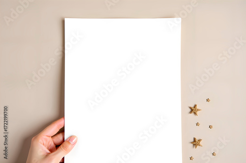 Hand Holding Blank Paper with Gold Star Decorations on Neutral B