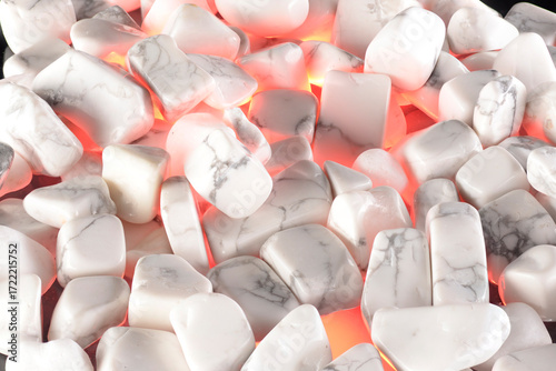White polished stones texture background and red light