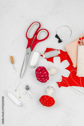 Halloween craft concept. Soft sewed fly agaric mushrooms, creative process, professional tools