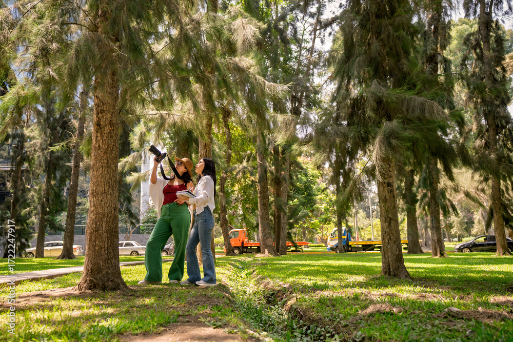 Fototapeta premium Female botanical biology students doing fieldwork in urban park