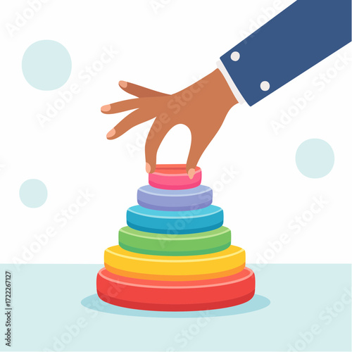 Hand Placing Ring Stacker Toy Piece on Colorful Pyramid
