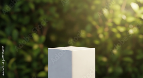 Minimalist white stone podium for product presentation with a blurry green garden background