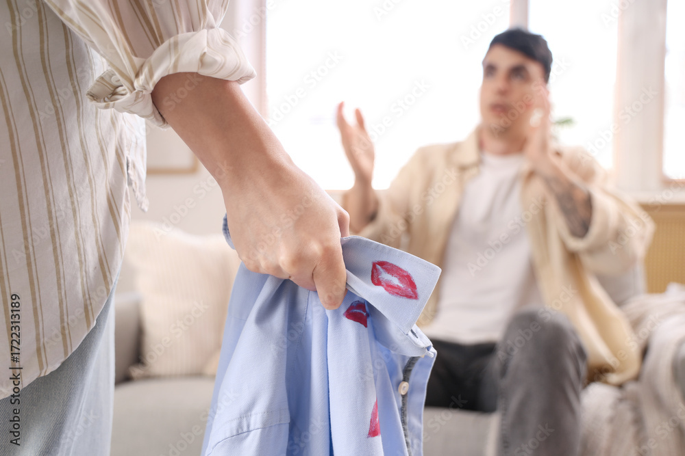 Φωτογραφία Wife holding shirt of husband with kiss marks at home