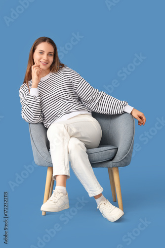 Young woman sitting in grey...