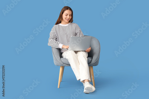 Young woman using laptop in...