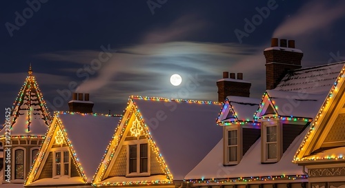 Snow covered houses decorated with christmas lights under a full moon at night, creating a magical and festive winter wonderland scene