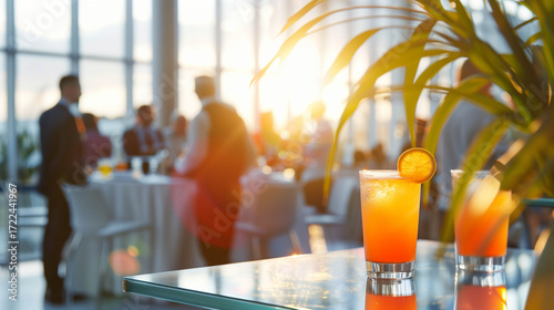 Elegant corporate cocktail party with guests socializing at sunset in modern venue