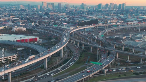 Aerial view of commuters driving cars and trucks on a complex highway interchange system during rush hour in Oakland, California, USA.