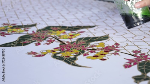 Close up of a flower being coloured on pattern traditional batik from indonesia . 4k batik. 4k art
