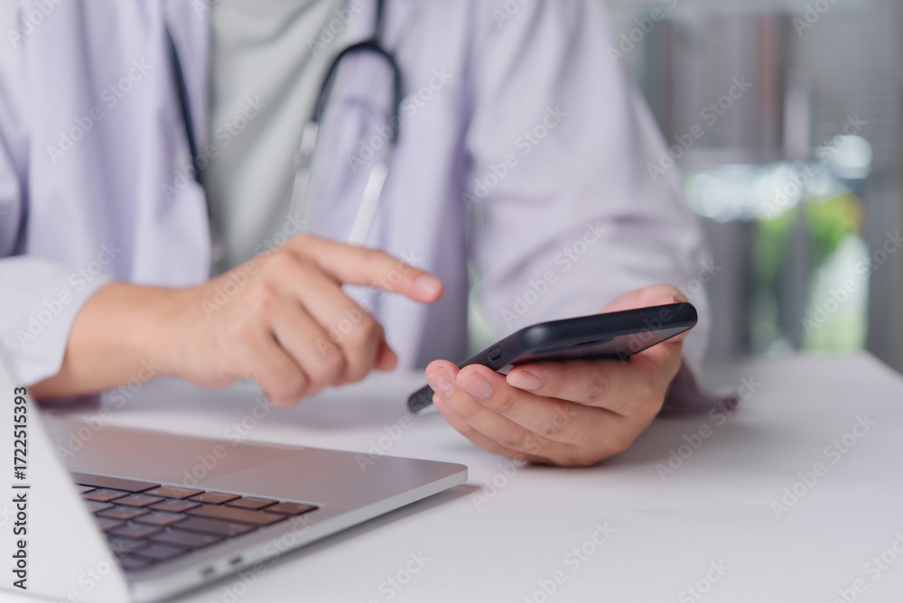 Fototapeta premium Healthcare professional checks mobile phone in office for appointment alert email consultation telehealth coordination digital record management productivity efficiency concept.