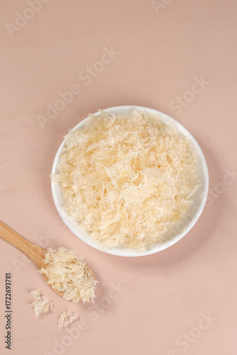 Tremella Snow Ear Mushroom Dried Silver Ear Fungus in White Bowl on Pink Background
