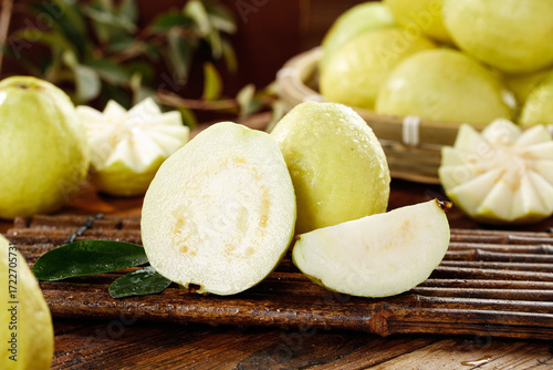 Fresh Guava Fruit Slices on Wooden Board with Cream Colored Flesh and Heart Seeds