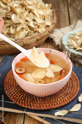 Traditional Chinese Lily Bulb Soup with Mushrooms and Red Dates in Pink Bowl on Wooden Table