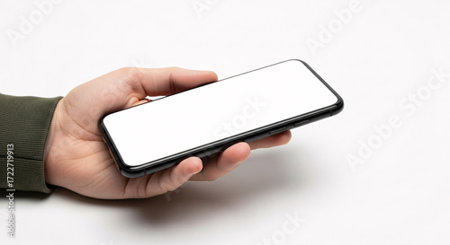 Close-up shot of a person's hand holding a modern smartphone with a blank screen.