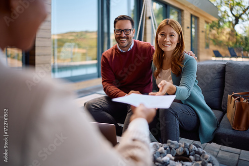 Happy couple receiving contract to sign from their insurance agent.