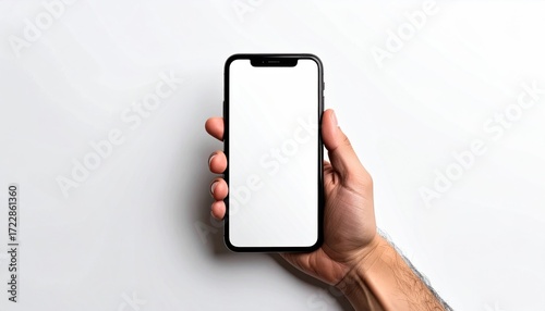 A hand holds a black-rimmed phone with a blank white screen, isolated on a plain white surface. The hand is slightly tanned