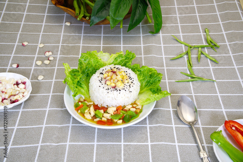 Close-up delicious rice topped with corn, vegetables, pepper, spoon, top view